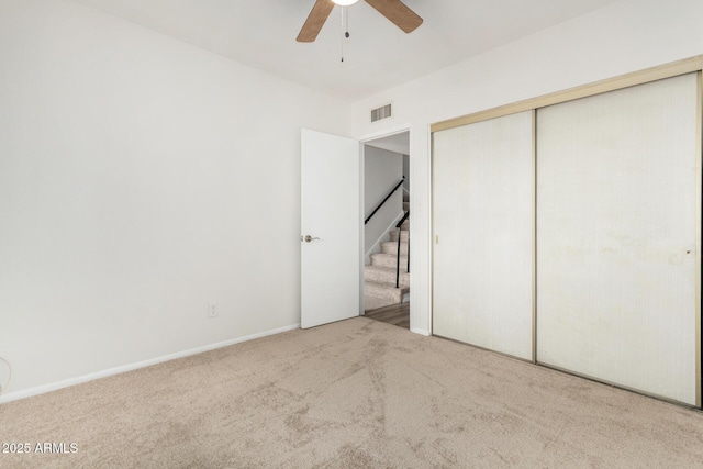 unfurnished bedroom featuring a closet, visible vents, carpet flooring, ceiling fan, and baseboards