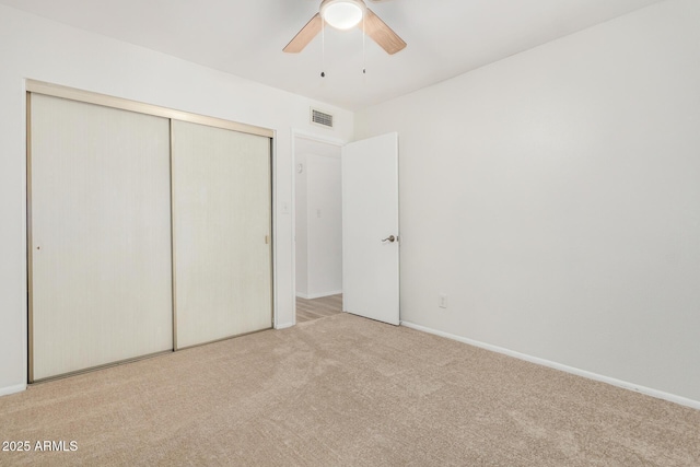 unfurnished bedroom featuring ceiling fan, carpet floors, visible vents, baseboards, and a closet