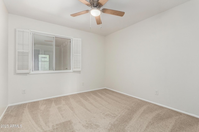 carpeted spare room with ceiling fan and baseboards