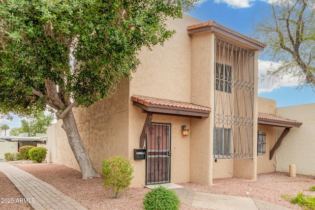 view of front facade featuring a tiled roof and stucco siding