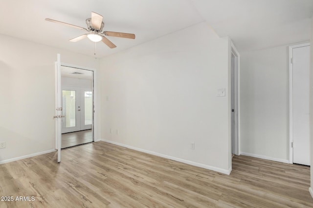 unfurnished room with light wood-style floors, baseboards, a ceiling fan, and french doors