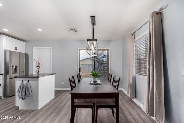 dining space featuring an inviting chandelier, light hardwood / wood-style flooring, and a wealth of natural light