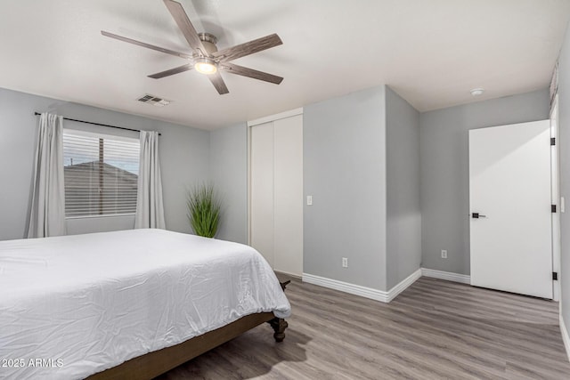 bedroom featuring ceiling fan, wood-type flooring, and a closet