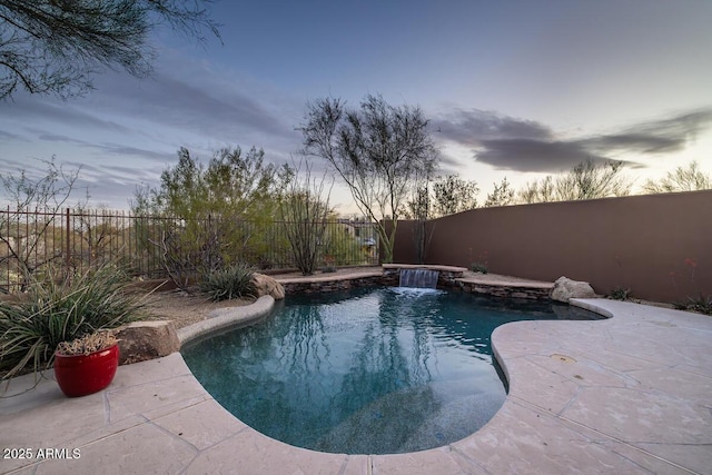 pool at dusk featuring a patio area, a fenced in pool, and a fenced backyard