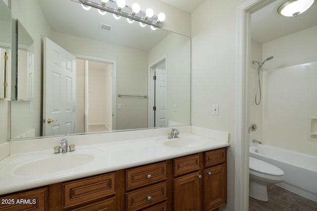 bathroom featuring double vanity, visible vents, toilet, and a sink