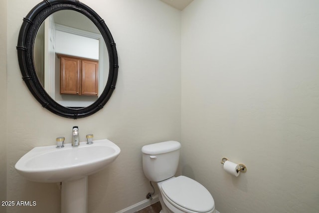 bathroom with toilet and baseboards