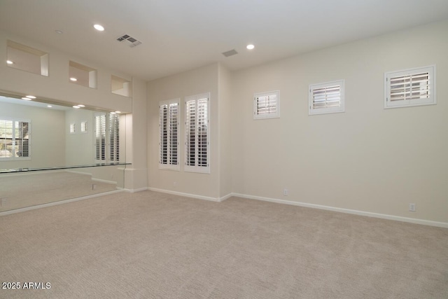 empty room featuring recessed lighting, visible vents, baseboards, and light colored carpet