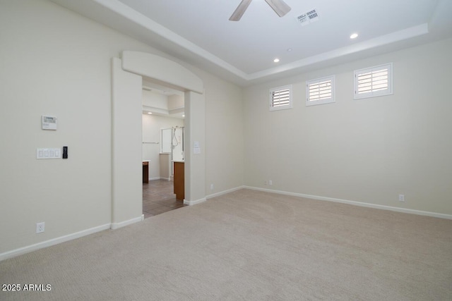 unfurnished bedroom featuring visible vents, a raised ceiling, baseboards, and carpet flooring