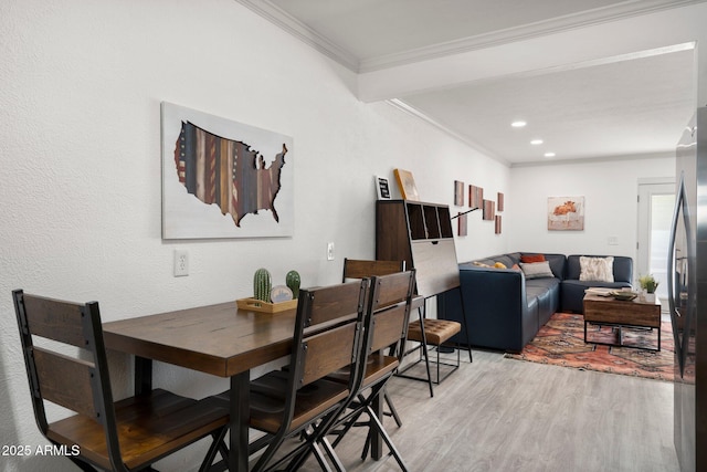 dining area featuring crown molding and light wood-type flooring