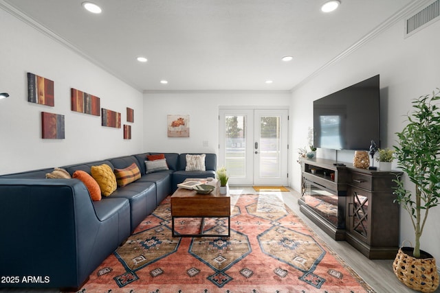 living room with crown molding, french doors, and light wood-type flooring