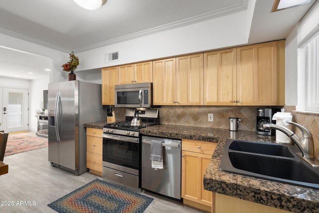 kitchen featuring sink, crown molding, light brown cabinets, appliances with stainless steel finishes, and light hardwood / wood-style floors