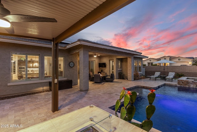 view of swimming pool featuring an outdoor fire pit, ceiling fan, and a patio area