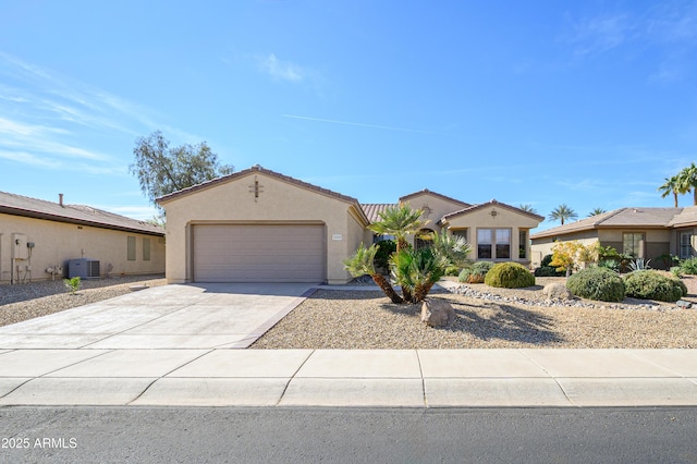 mediterranean / spanish-style house with central air condition unit, a garage, a tile roof, concrete driveway, and stucco siding