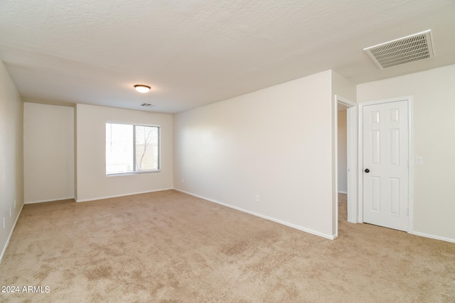 carpeted empty room with a textured ceiling