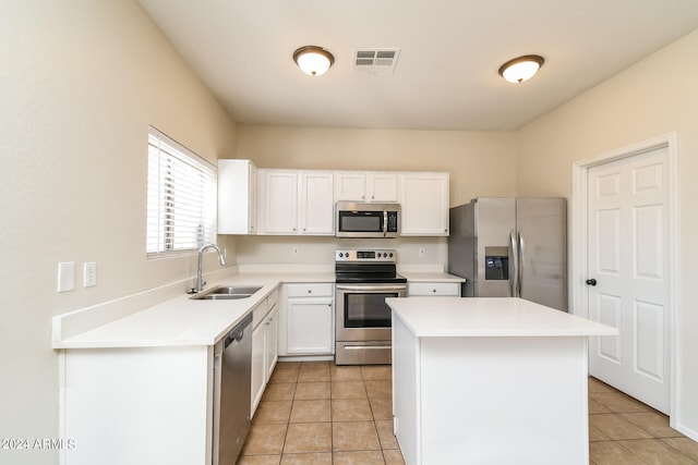 kitchen featuring appliances with stainless steel finishes, sink, a kitchen island, and white cabinets