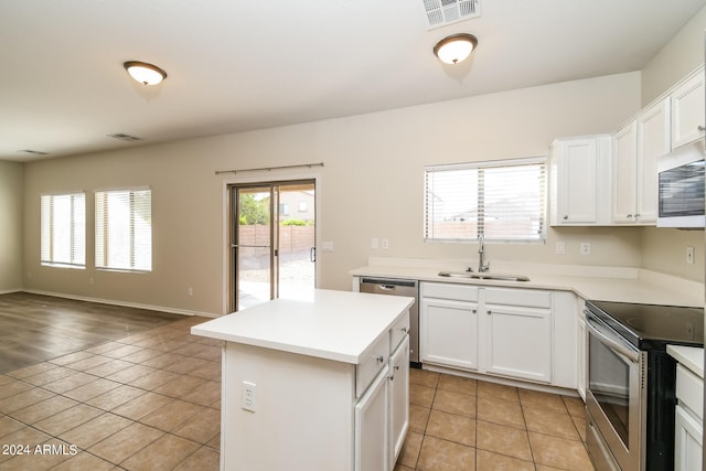 kitchen with white cabinetry, appliances with stainless steel finishes, sink, and a kitchen island