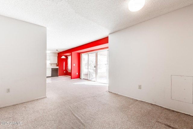 carpeted empty room featuring a textured ceiling