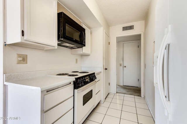 kitchen featuring range with electric stovetop, white cabinets, white fridge, light tile patterned floors, and a textured ceiling