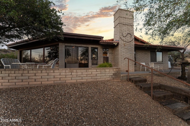 27610 W Gill Rd, Morristown, AZ 85342 - back of house at dusk featuring a chimney and a patio area