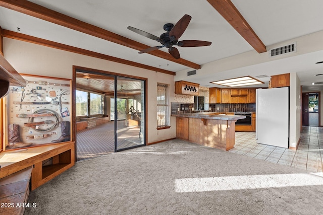 27610 W Gill Rd, Morristown, AZ 85342 - kitchen featuring freestanding refrigerator, beamed ceiling, brown cabinetry, plenty of natural light, and a peninsula