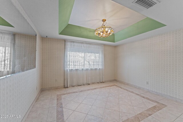 27610 W Gill Rd, Morristown, AZ 85342 - unfurnished room with a tray ceiling, tile patterned flooring, inlaid floor details, a chandelier, and wallpapered walls
