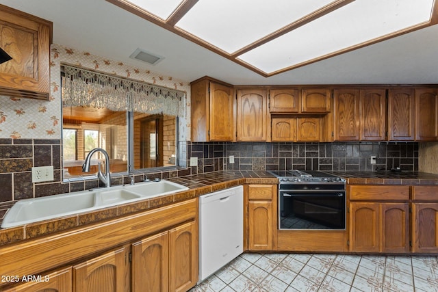 27610 W Gill Rd, Morristown, AZ 85342 - kitchen featuring white dishwasher, range, a sink, brown cabinets, and tasteful backsplash
