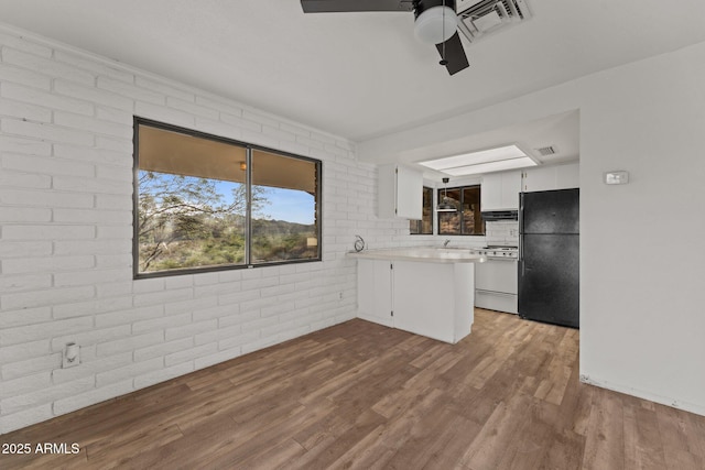 27610 W Gill Rd, Morristown, AZ 85342 - kitchen with freestanding refrigerator, white gas range oven, ceiling fan, a peninsula, and ventilation hood