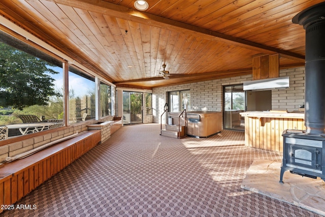 27610 W Gill Rd, Morristown, AZ 85342 - sunroom featuring a wood stove, brick wall, wooden ceiling, and carpet flooring
