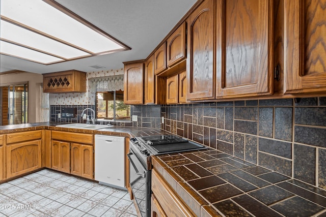 27610 W Gill Rd, Morristown, AZ 85342 - kitchen with range, dishwasher, a sink, decorative backsplash, and brown cabinetry