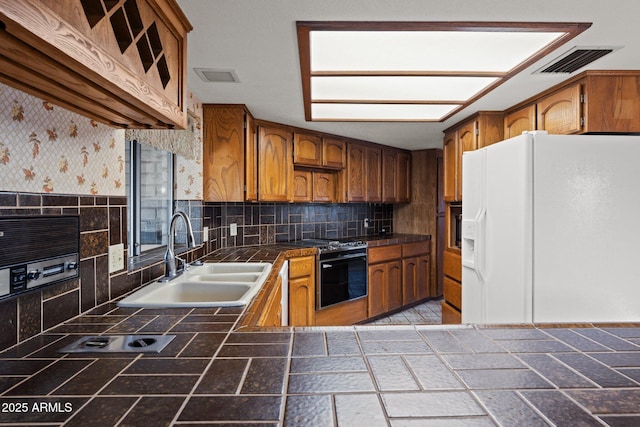27610 W Gill Rd, Morristown, AZ 85342 - kitchen featuring white refrigerator with ice dispenser, a sink, range with gas stovetop, brown cabinetry, and tile countertops