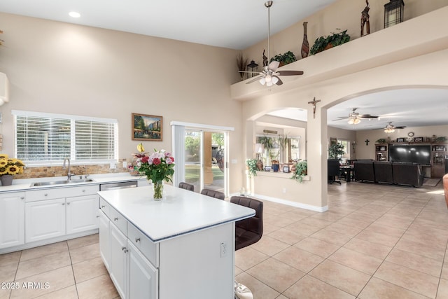 kitchen featuring sink, white cabinets, a center island, light tile patterned floors, and ceiling fan