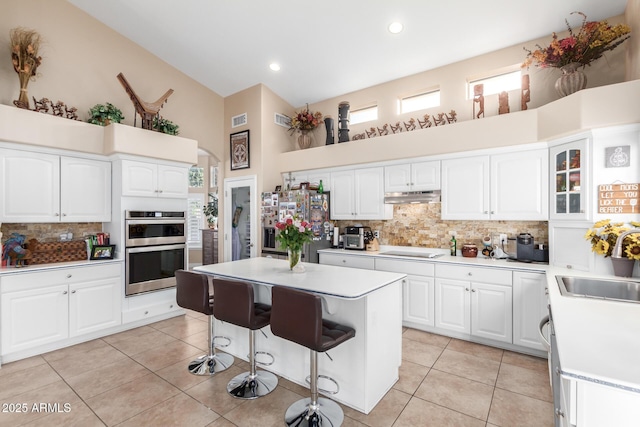 kitchen with white cabinetry, a breakfast bar area, appliances with stainless steel finishes, and a kitchen island