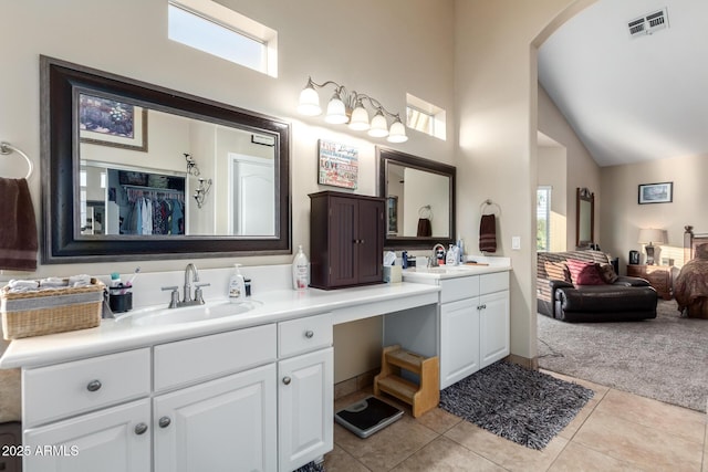 bathroom with vanity, plenty of natural light, tile patterned floors, and high vaulted ceiling