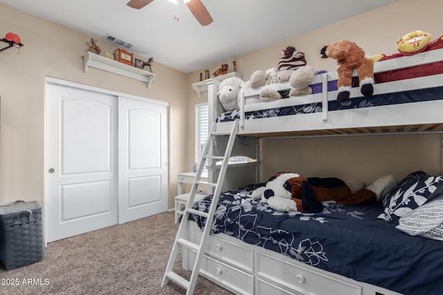 carpeted bedroom with ceiling fan and a closet