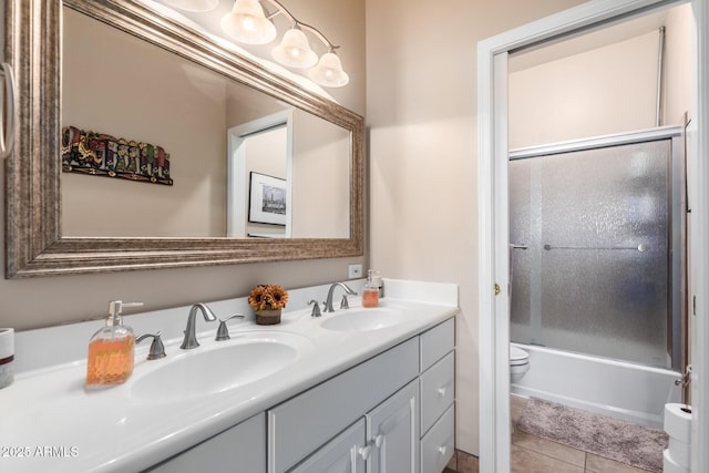 full bathroom featuring vanity, tile patterned floors, shower / bath combination with glass door, and toilet