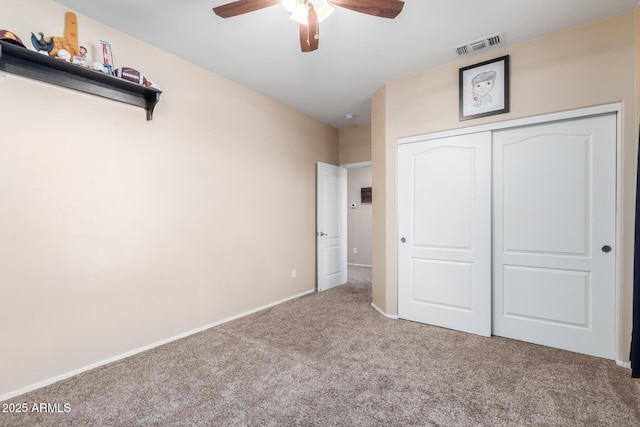 unfurnished bedroom with ceiling fan, light colored carpet, and a closet