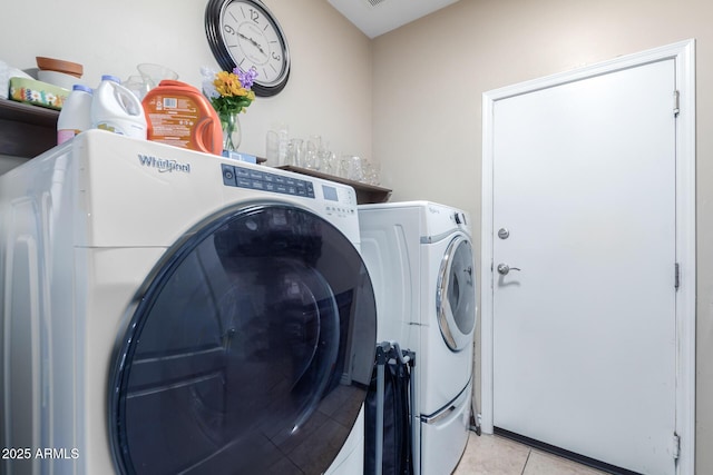 laundry area featuring washer and dryer and light tile patterned floors