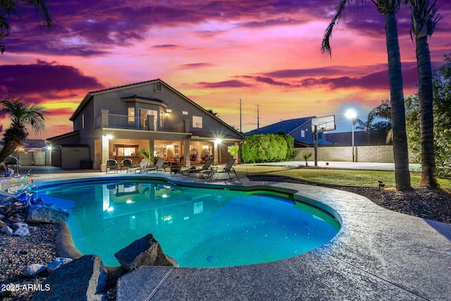 pool at dusk featuring a patio area