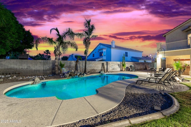 pool at dusk featuring a patio