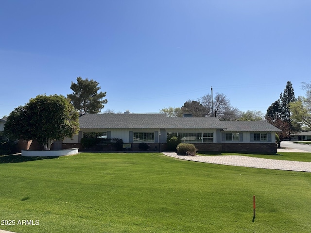 single story home featuring a front lawn