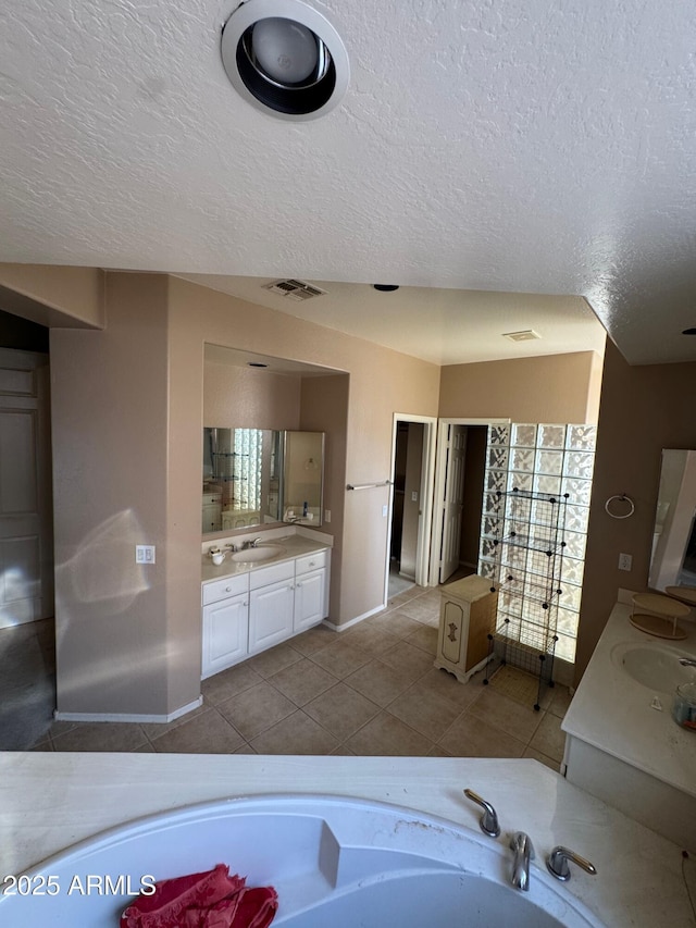 bathroom featuring tile patterned flooring, vanity, and a textured ceiling