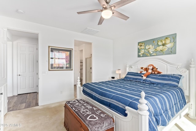 bedroom with ceiling fan, baseboards, visible vents, and light carpet