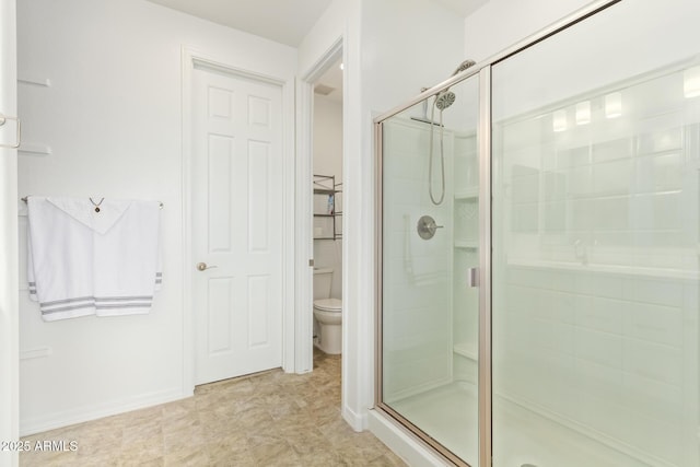 full bathroom featuring a shower stall, toilet, and baseboards