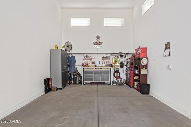 garage with a workshop area and baseboards