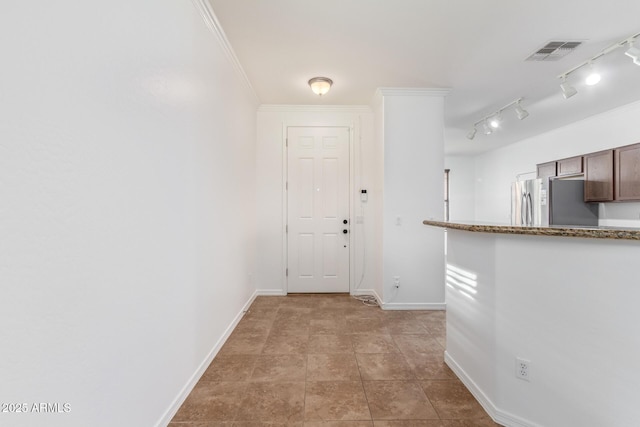 interior space with crown molding and stainless steel refrigerator