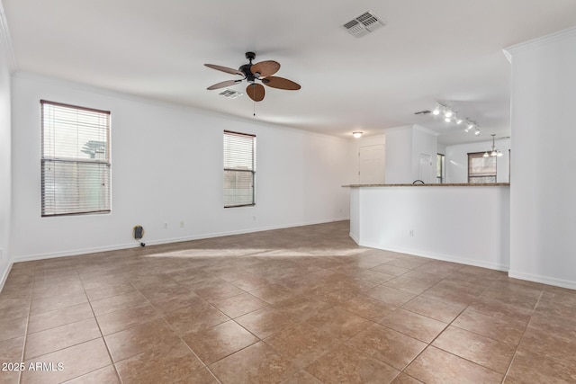 spare room featuring crown molding, ceiling fan, light tile patterned floors, and a wealth of natural light