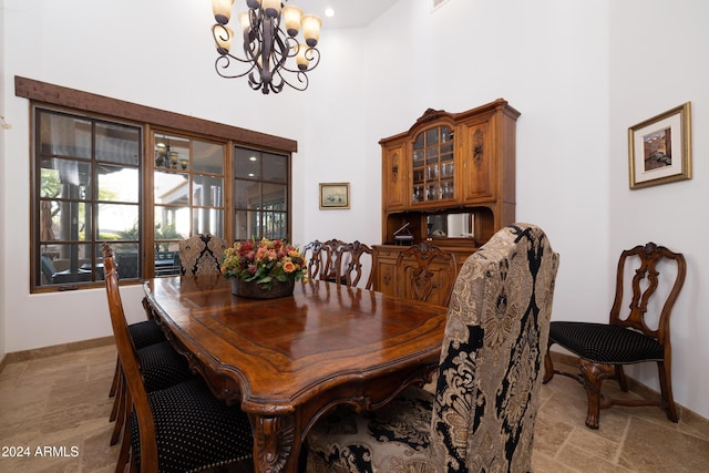 dining area with a high ceiling and a notable chandelier