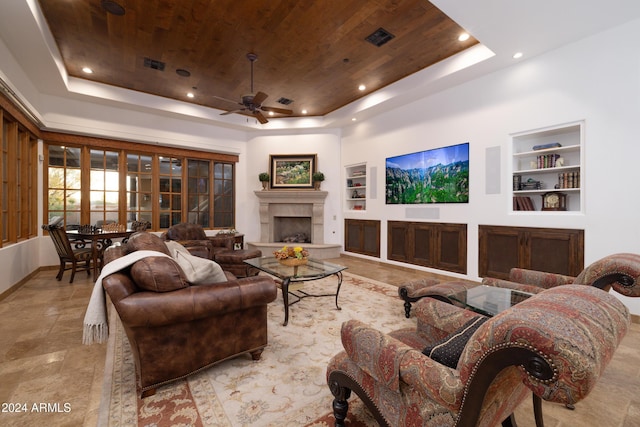 living room featuring a raised ceiling, ceiling fan, built in features, and wood ceiling