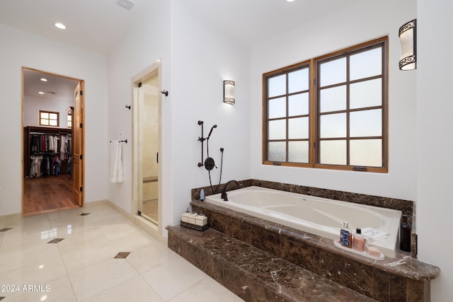 bathroom with tile patterned flooring and shower with separate bathtub