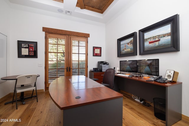 office featuring french doors, light hardwood / wood-style floors, and coffered ceiling